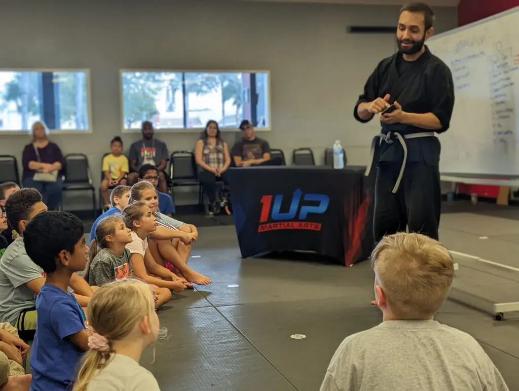 Instructor coaching a camper at 1UP Martial Arts