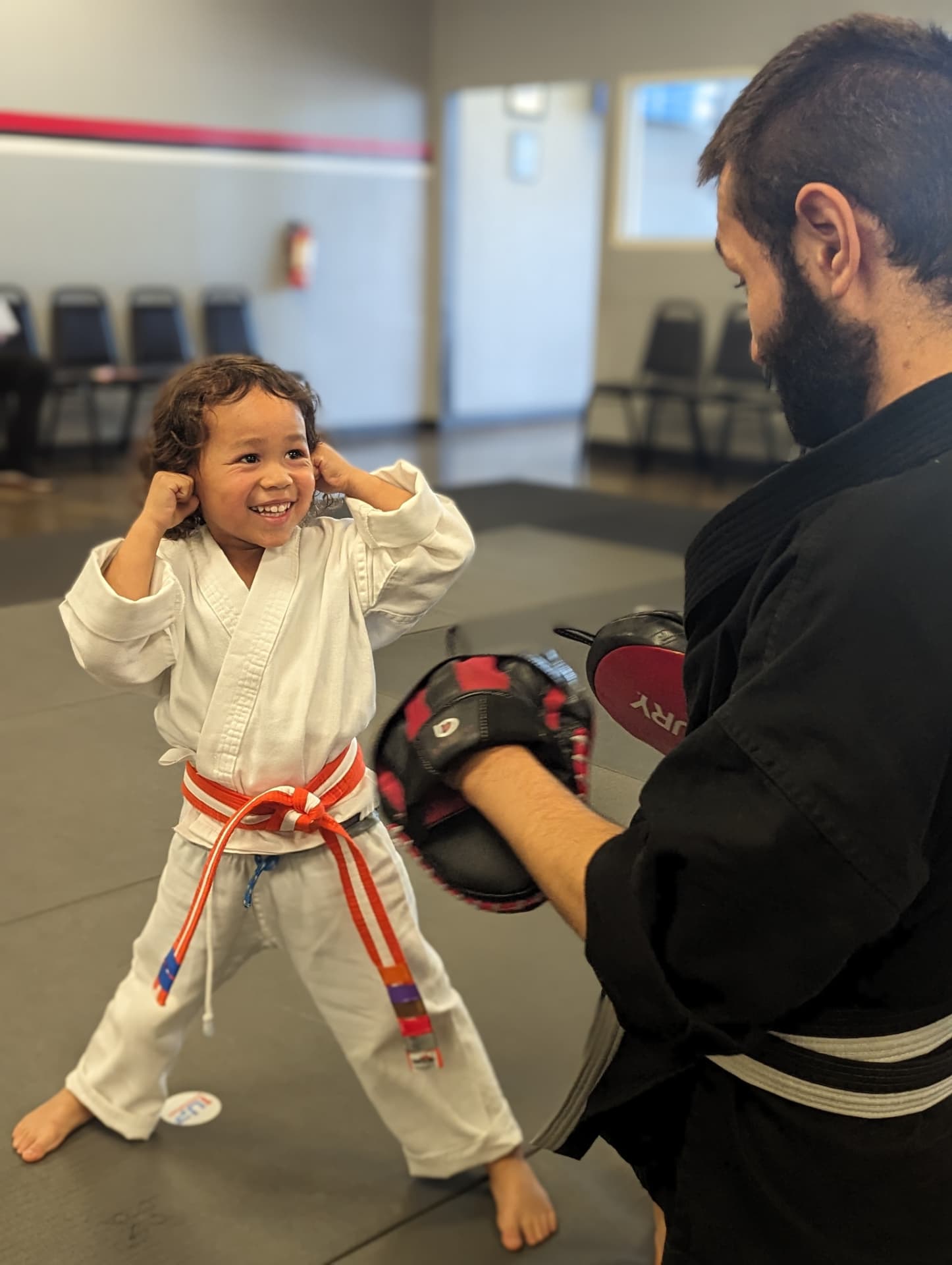 Young student in a 1UP uniform training on the mat